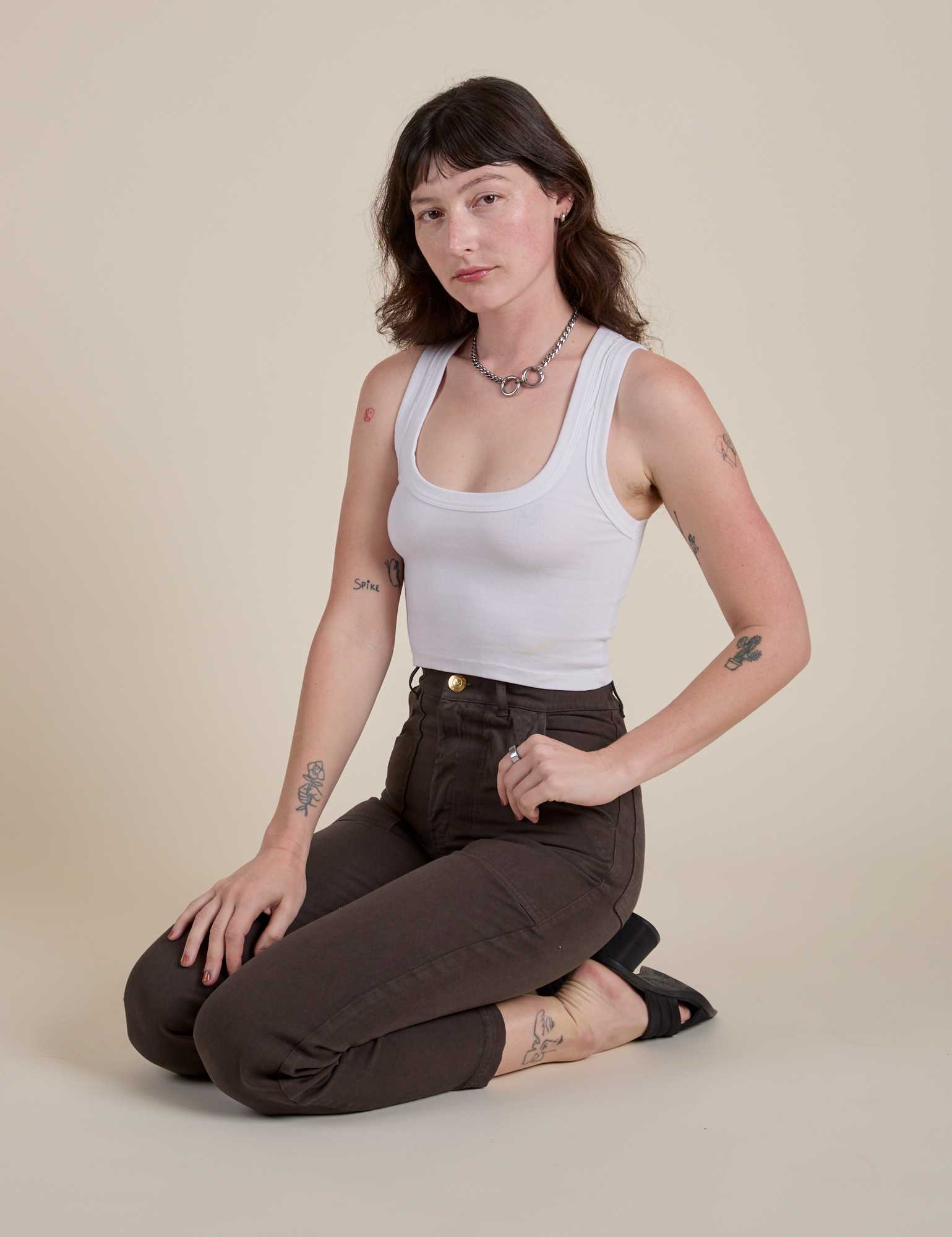 Work Pants in Espresso Brown and Cropped Tank in Vintage Tee White worn by Alex