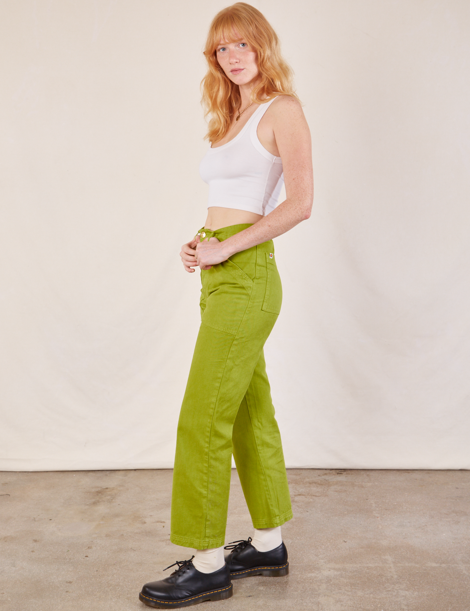 Side view of Work Pants in Gross Green and Cropped Tank in vintage tee off-white on Margaret