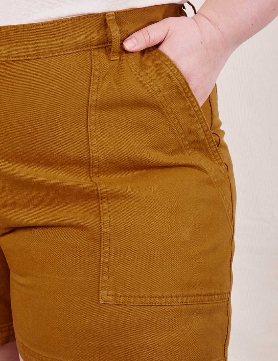 Ashley has her hand in the front pocket of the Classic Work Shorts in Spicy Mustard