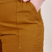 Ashley has her hand in the front pocket of the Classic Work Shorts in Spicy Mustard