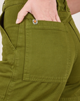 Classic Work Shorts in Summer Olive back pocket close up. Madeline has her hand in the pocket.
