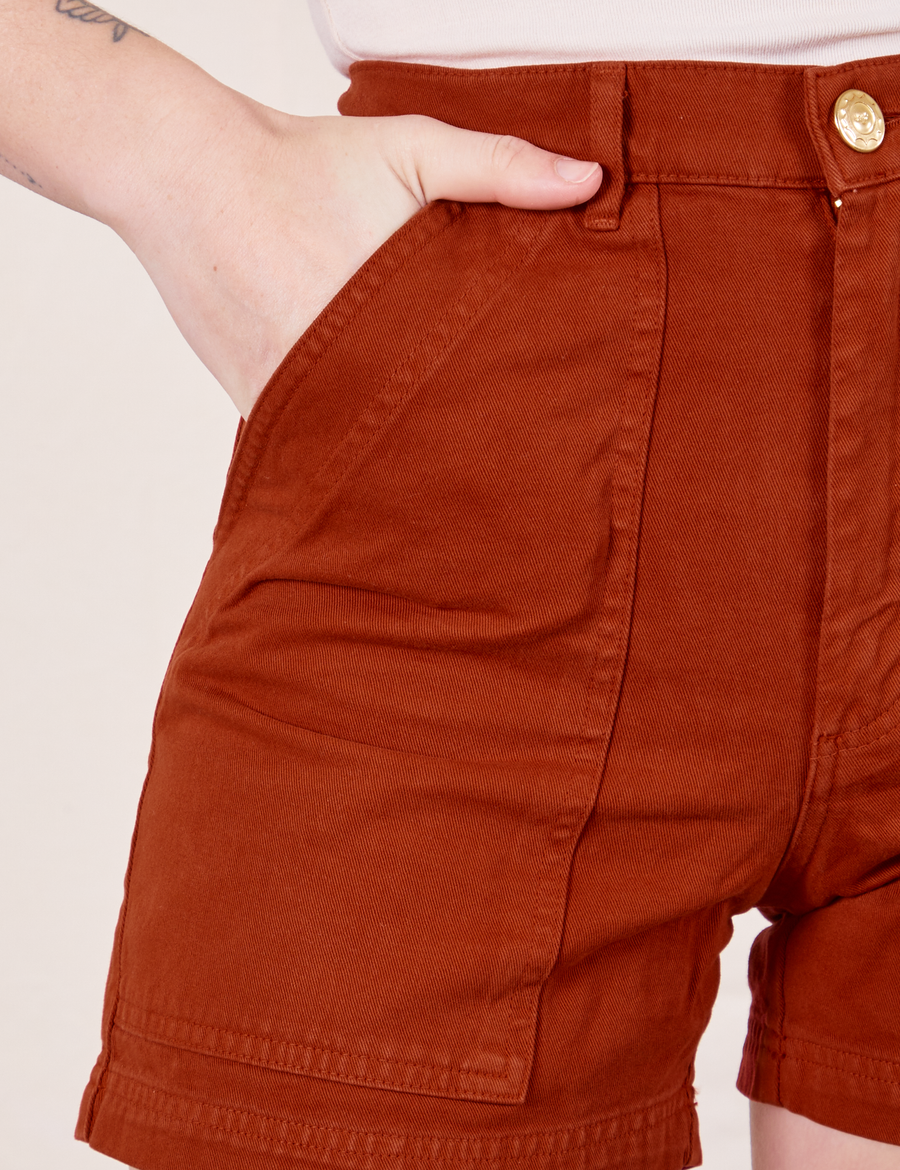 Classic Work Shorts in Paprika front close up. Alex has her hand in the pocket.