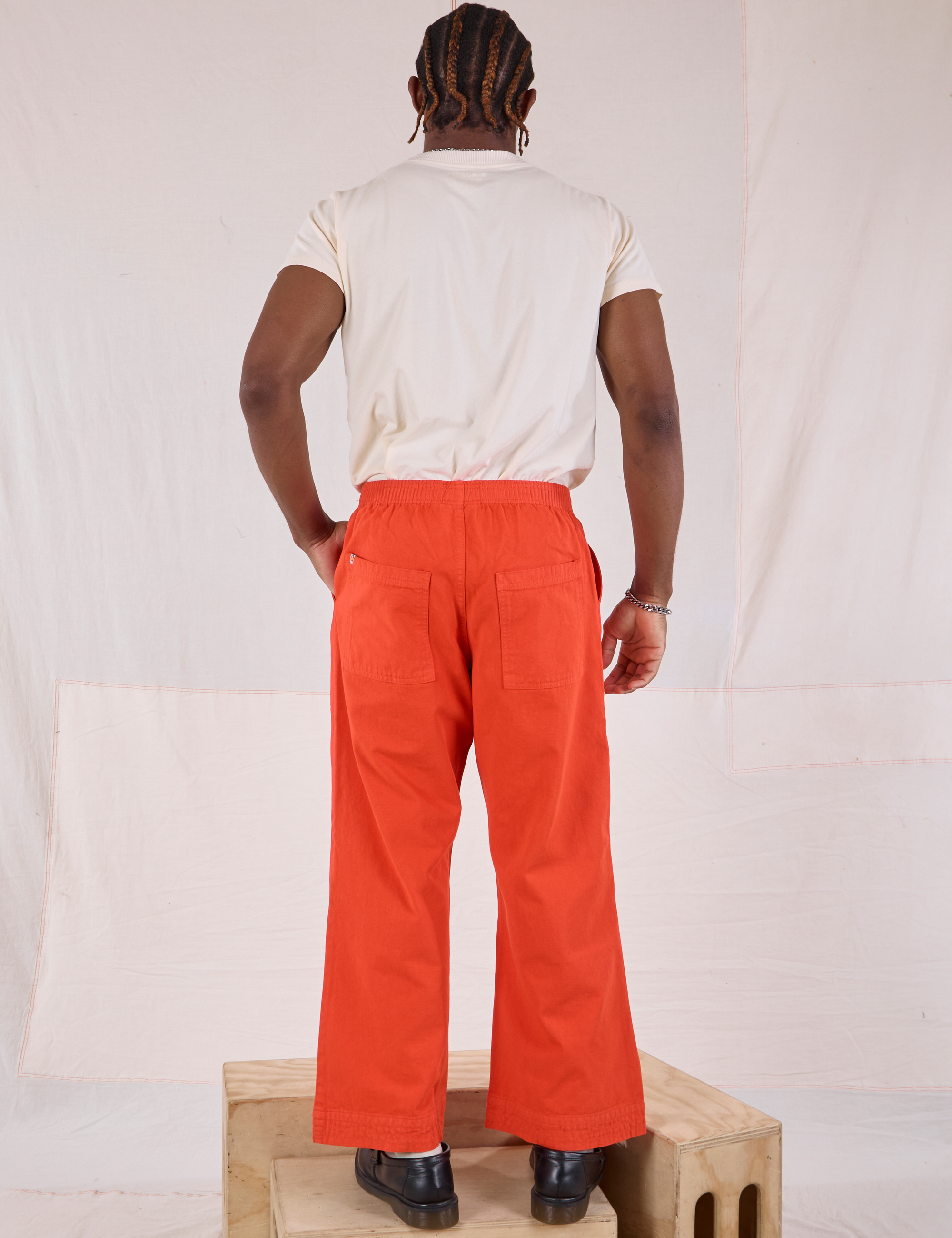 Back view of Action Pants in Chili Red and Organic Vintage Tee in Vintage Tee Off-White on Isaac