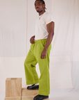 Side view of Action Pants in Gross Green and Organic Vintage Tee in Vintage Tee Off-White on Isaac