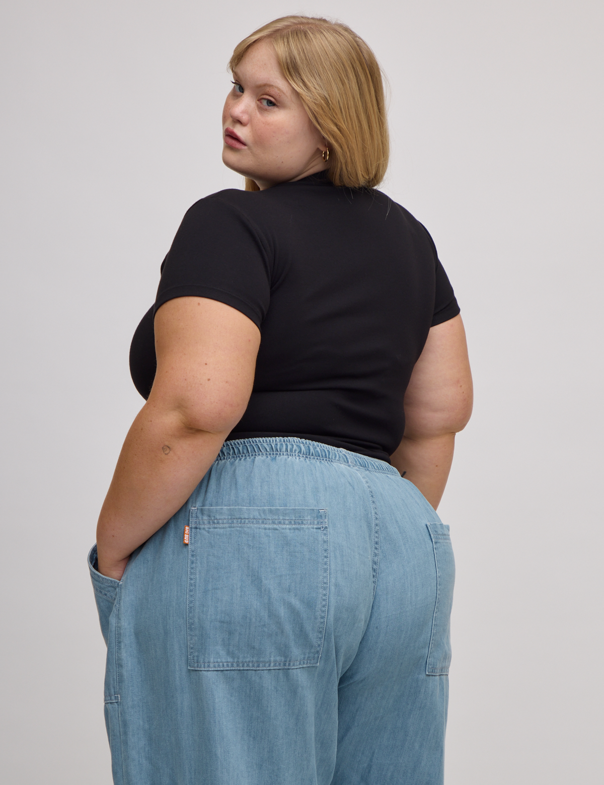 Angled back view of Baby Tee in Basic Black on Juliet