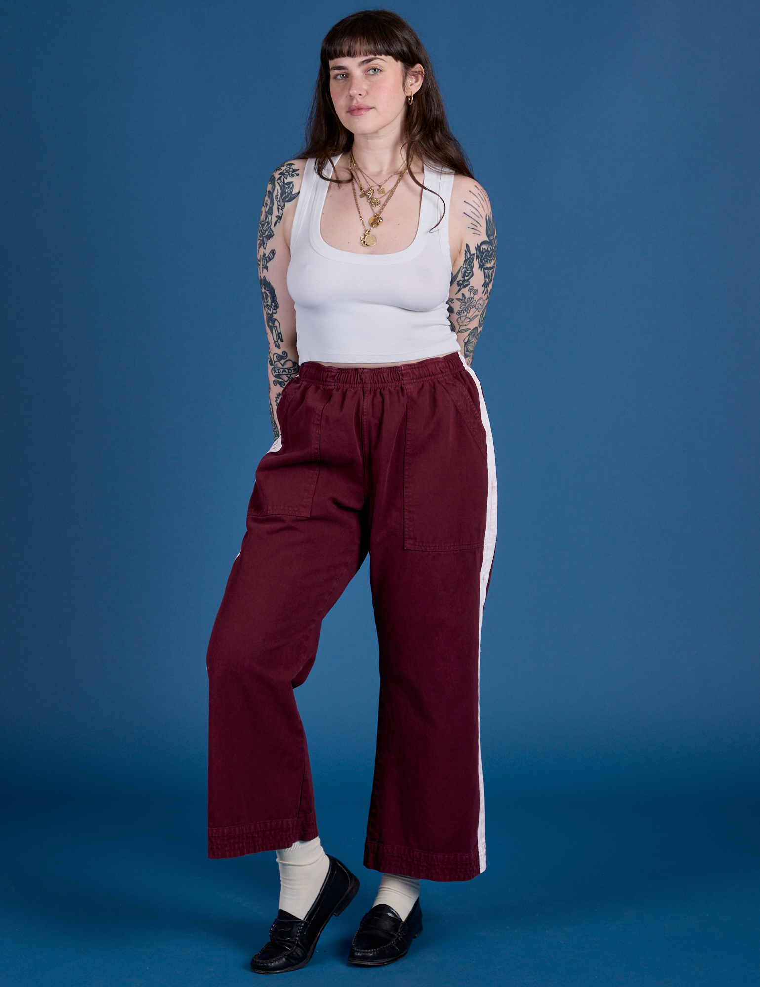 Sydney is 5’9” and wearing M Painted Action Pants in Red Wine paired with vintage tee white Cropped Tank