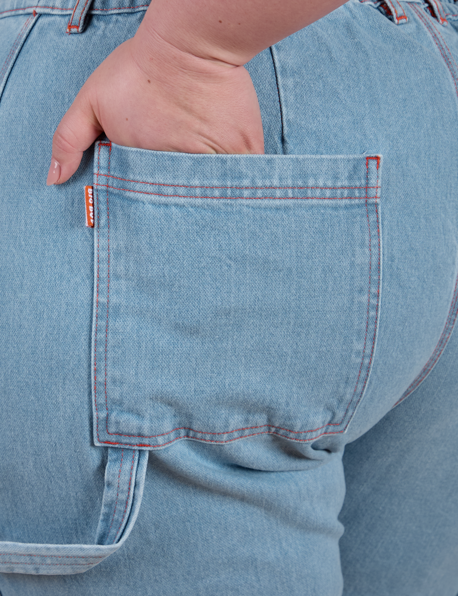 Close up of Ashley's hand in the back pocket of Carpenter Jeans in Light Wash
