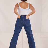 Back view of Carpenter Jeans in Dark Wash. Tiara has both hands in the back pocket.