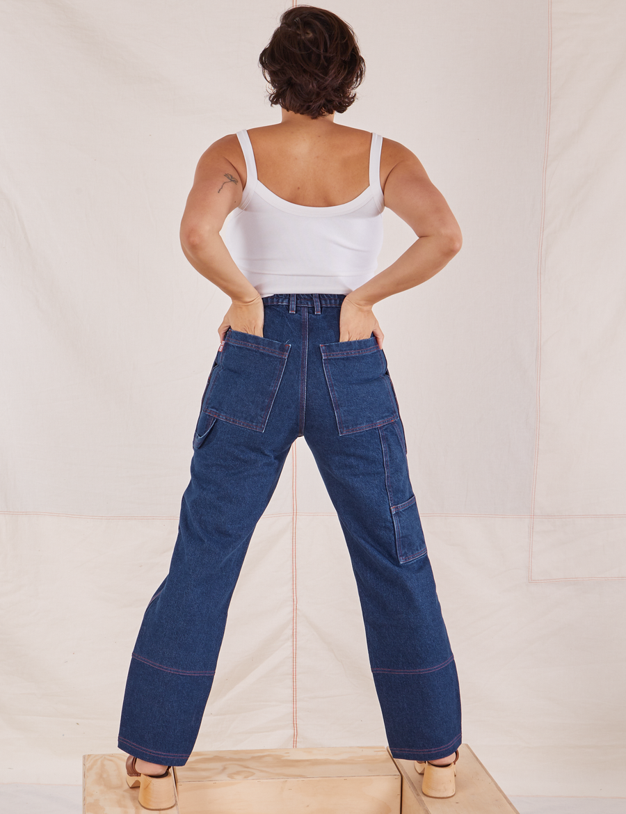 Back view of Carpenter Jeans in Dark Wash. Tiara has both hands in the back pocket.