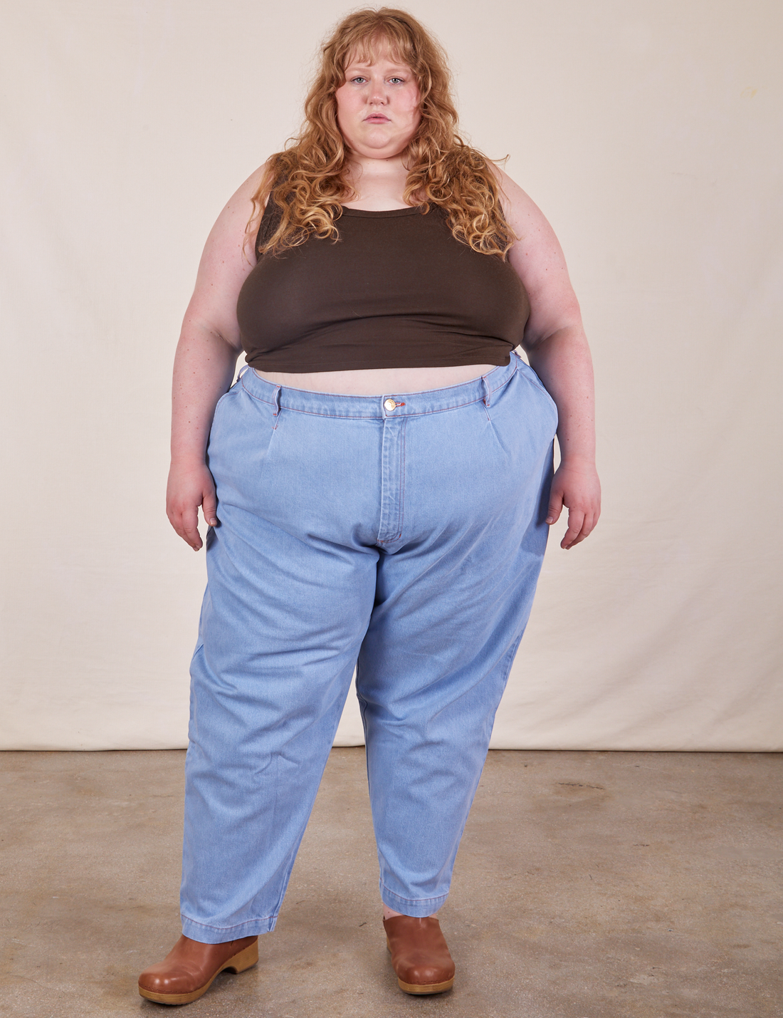 Catie is 5'11" and wearing 4XL Cropped Tank Top in Espresso Brown paired with light wash Denim Trousers