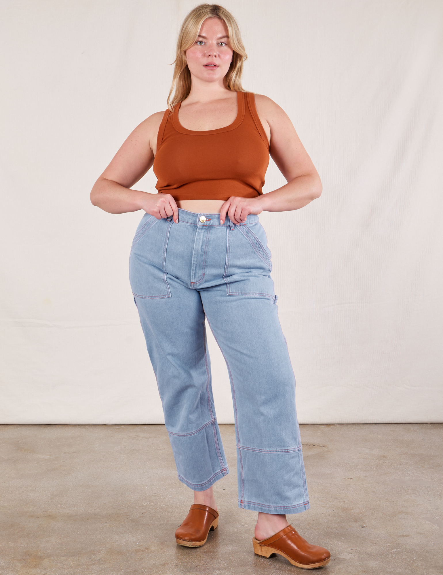 Lish is wearing Cropped Tank Top in Burnt Terracotta and light wash Carpenter Jeans