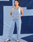 Tiara is 5'4" and wearing XS Indigo Denim Original Overalls in Light Wash