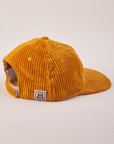 Side view of Dugout Corduroy Hat in Spicy Mustard. Big Bud label sewn on edge of hat.