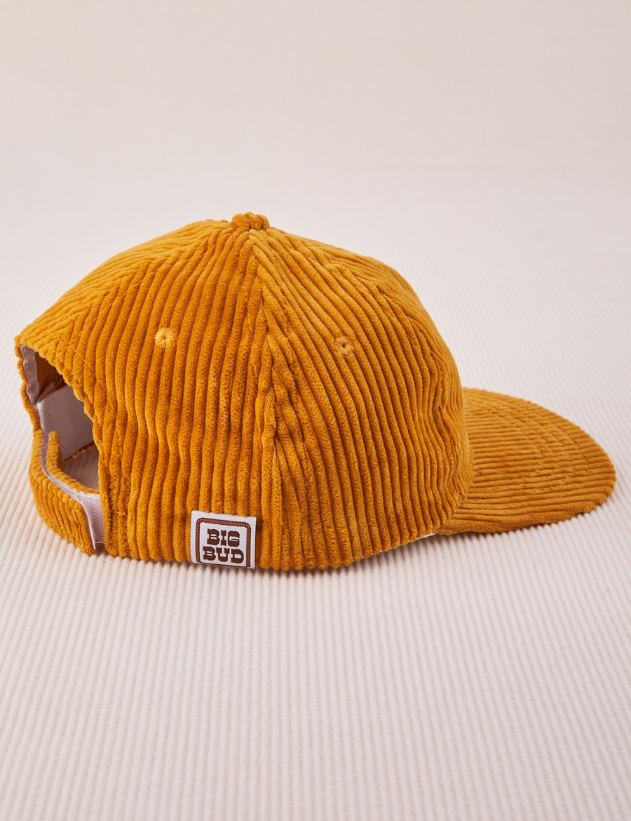 Side view of Dugout Corduroy Hat in Spicy Mustard. Big Bud label sewn on edge of hat.