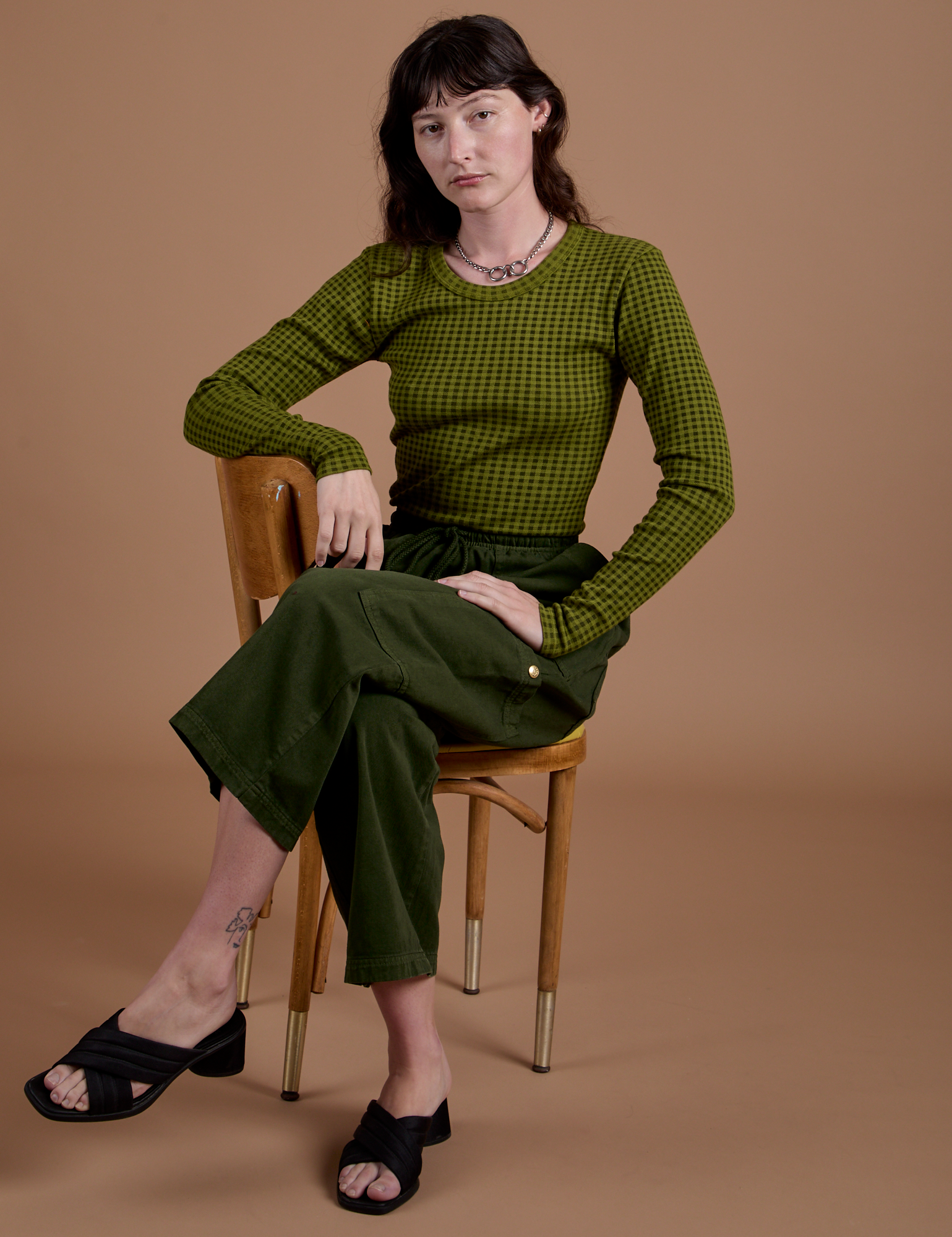 Alex is wearing Gingham Long Sleeve Baby Tee in Summer Olive and Drop Pocket Cargo Pants in Evergreen