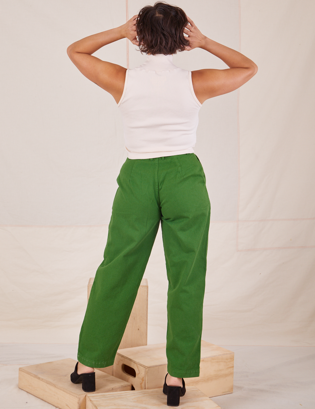 Back view of Heavyweight Trousers in Lawn Green and vintage off-white Sleeveless Turtleneck worn by Tiara