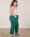 Side view of Work Pants in Hunter Green and vintage off-white Cropped Tank Top worn by Ashley