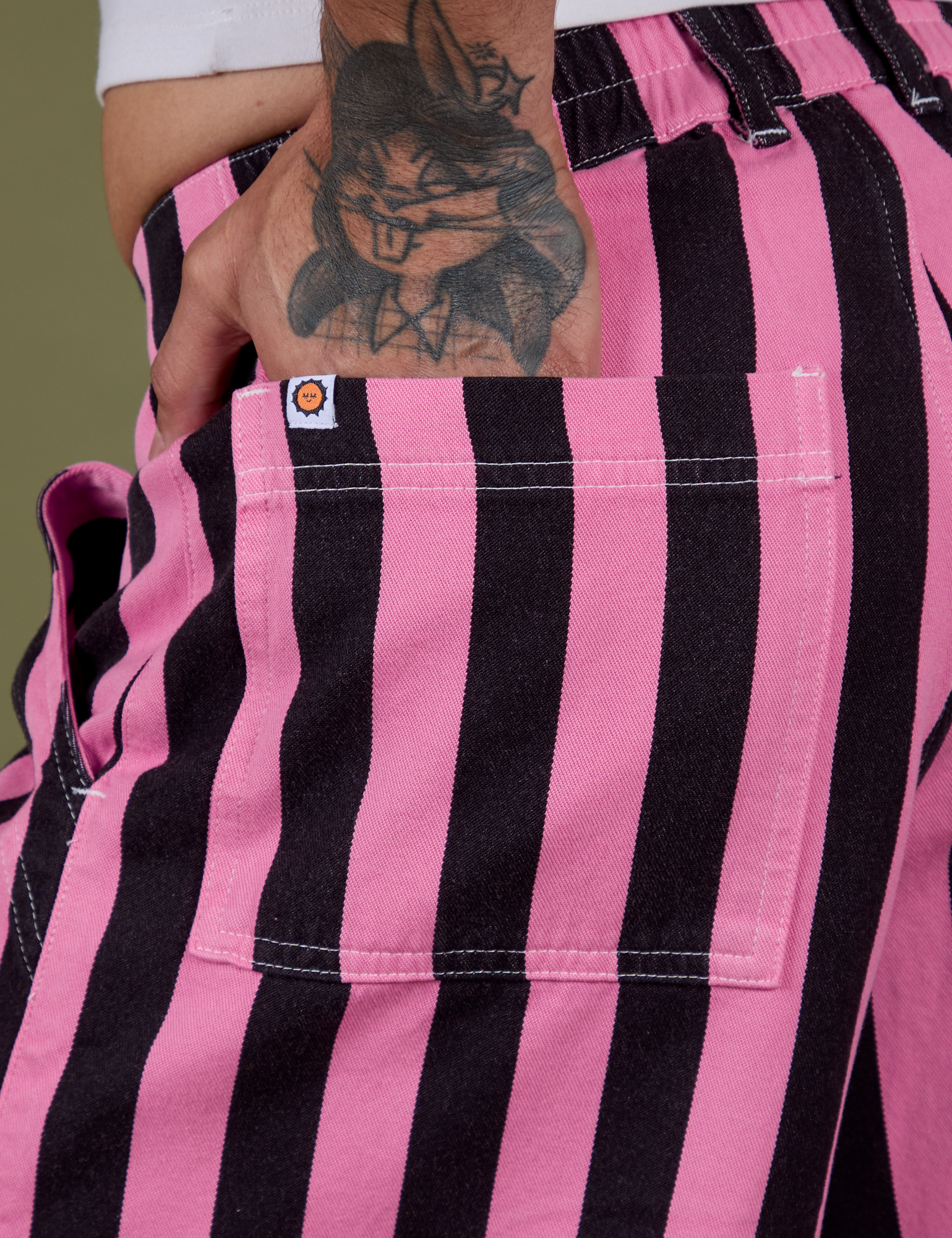 Close up of Jesse's hand in the back pocket of Longline Work Shorts in Bubblegum Pink