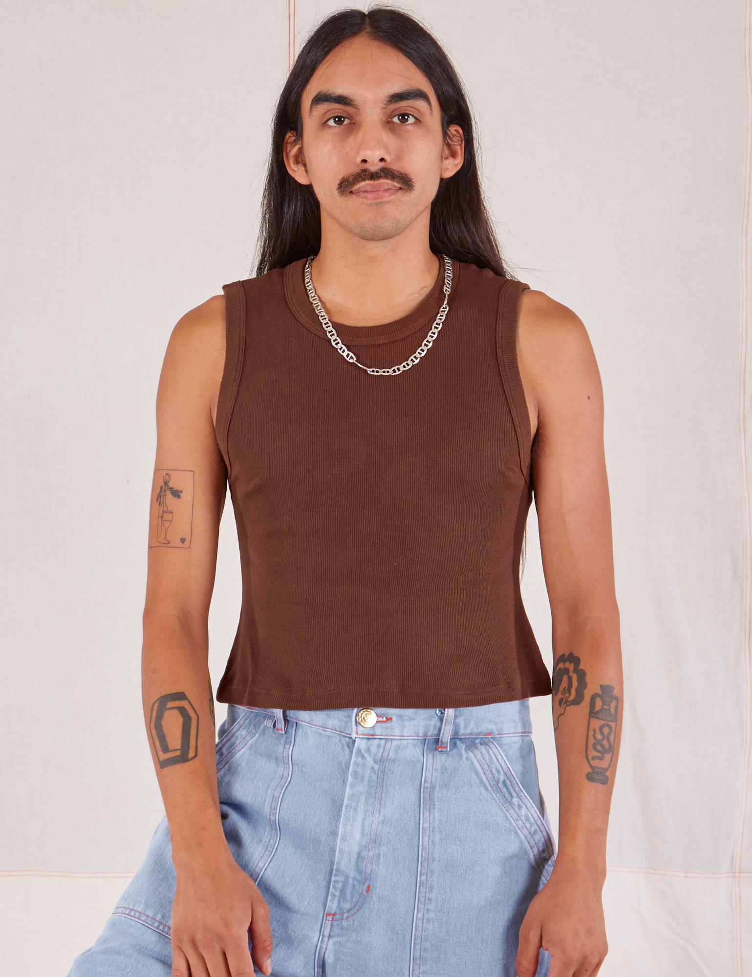 Anthony is 5’10” and wearing S Muscle Tee in Fudgesicle Brown