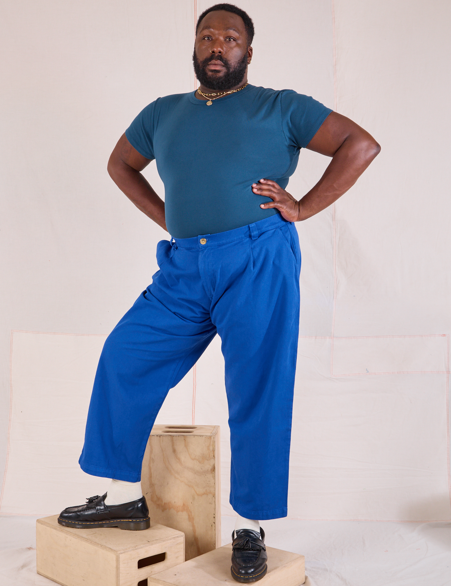 Elijah is 6&#39;3&quot; and wearing 1XL Mid-Rise Pleated Trousers in Royal Blue paired with lagoon Baby Tee