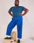 Elijah is 6'3" and wearing 1XL Mid-Rise Pleated Trousers in Royal Blue paired with lagoon Baby Tee