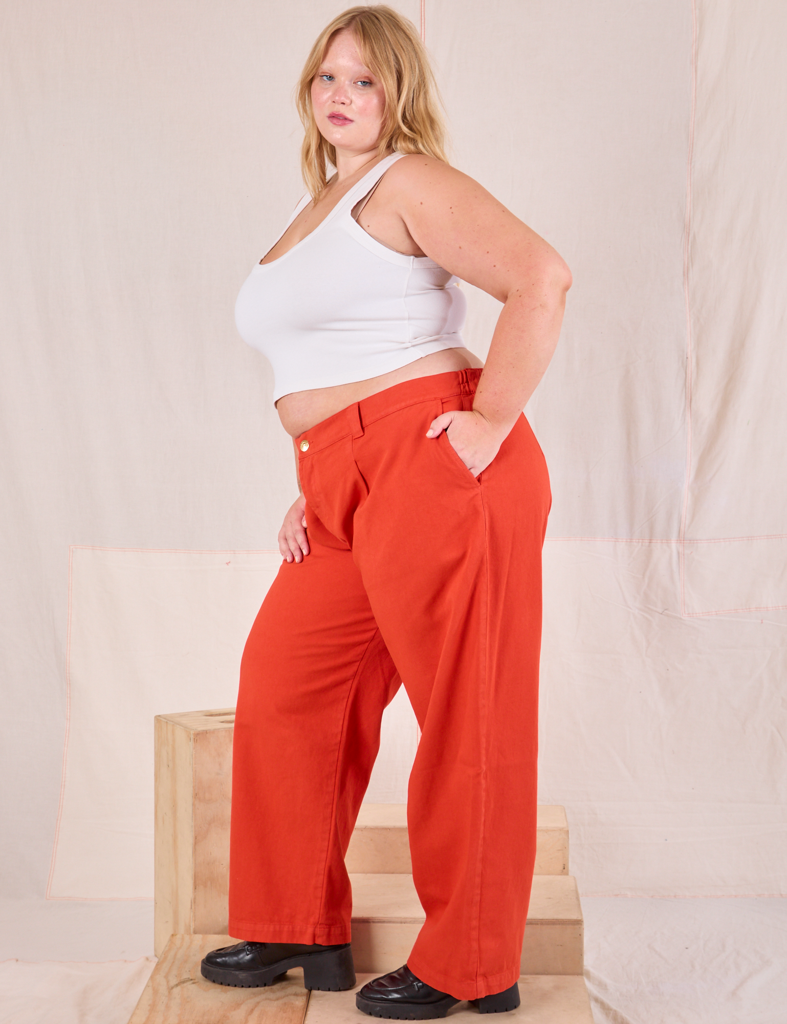 Side view of Mid-Rise Pleated Trousers in Chili Red and Cropped Tank in vintage tee off-white on Juliet