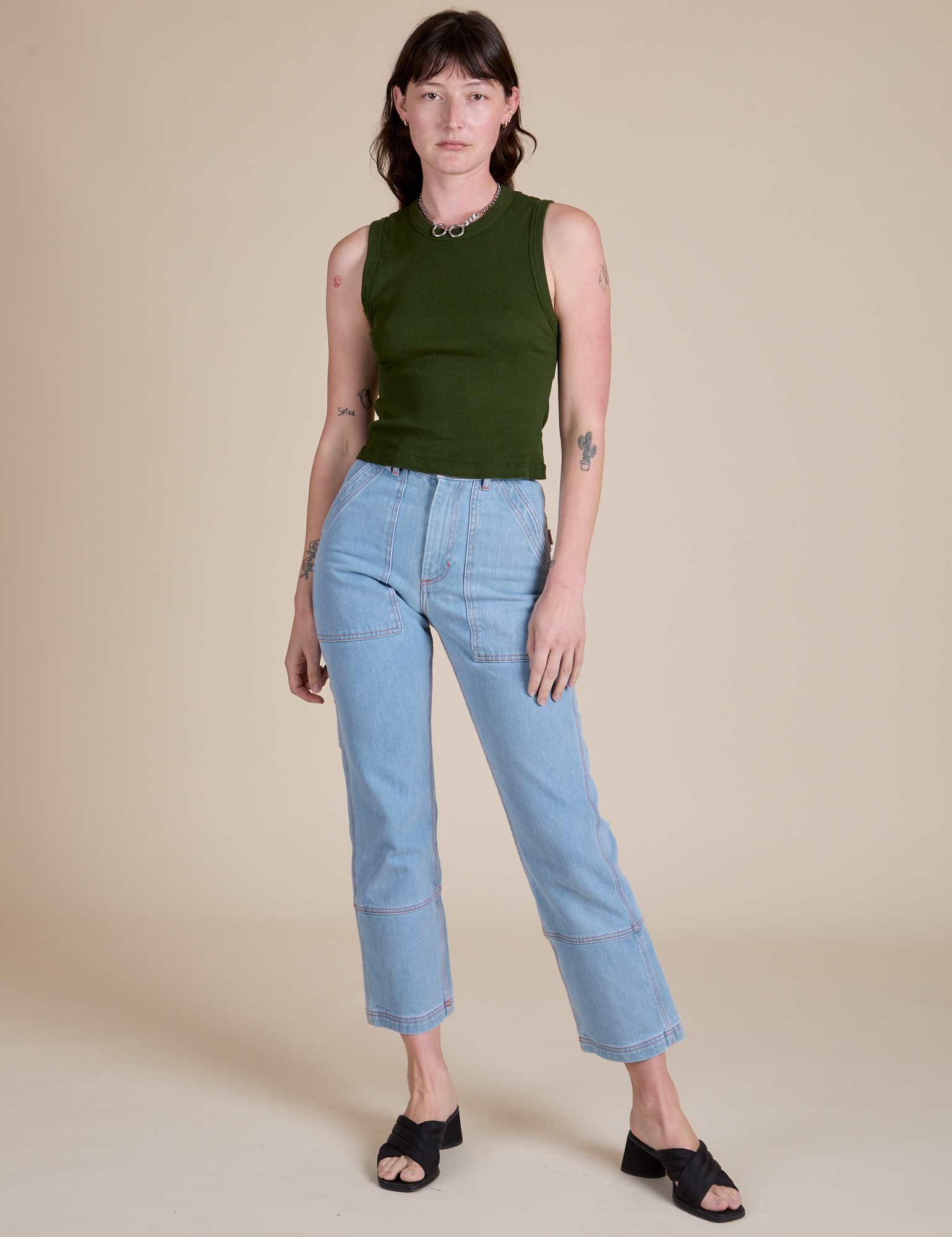 Alex is wearing Muscle Tee in Evergreen paired with light wash Carpenter Jeans