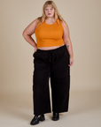 Juliet is wearing  Muscle Tee in Creamsicle Orange and black Drop Pocket Cargo Pants