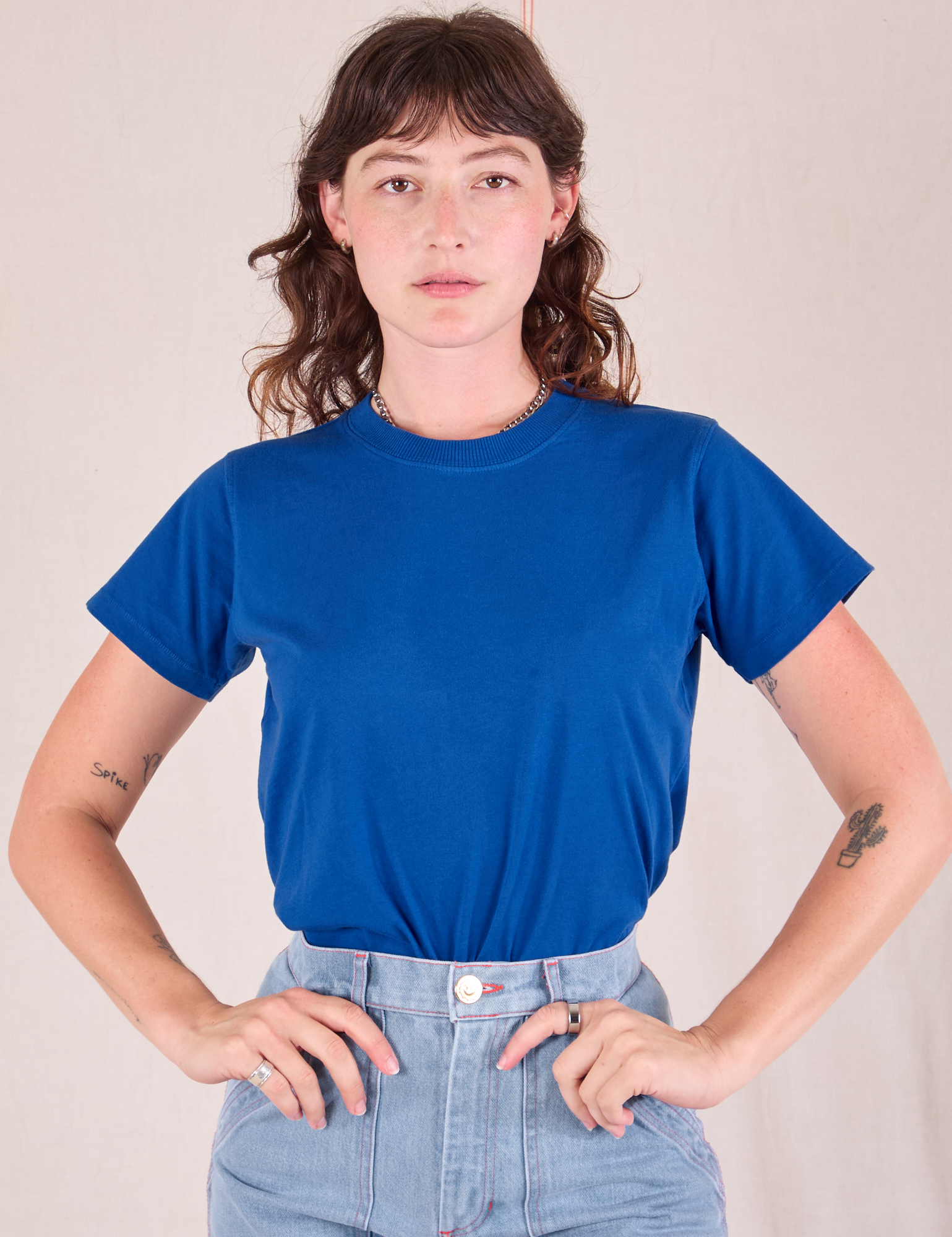 Alex is wearing Organic Vintage Tee in Royal Blue tucked into Carpenter Jeans in Light Wash