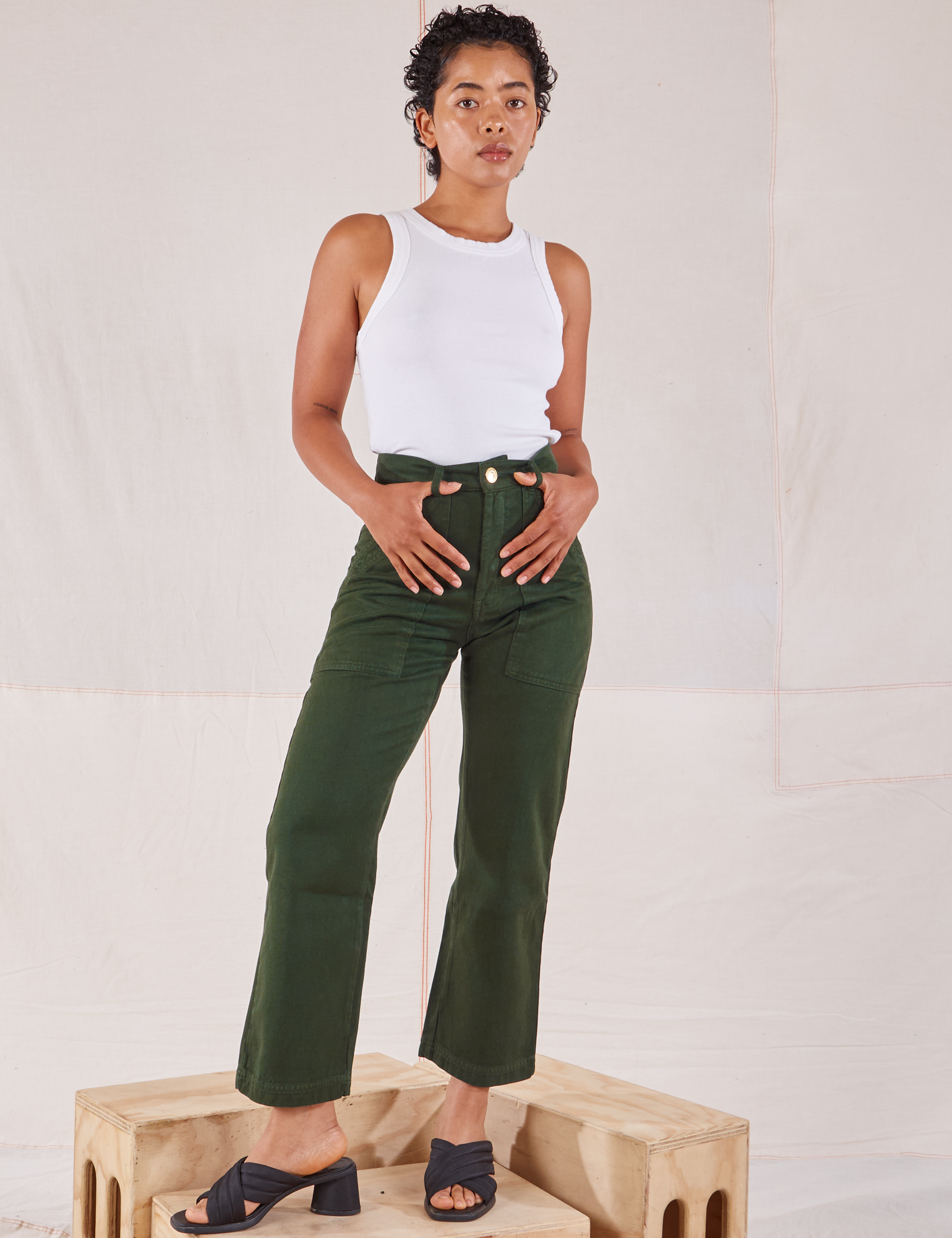 Mika is 5&#39;1&quot; and wearing Petite XXS Organic Work Pants in Swamp Green paired with Racerback Tank in vintage tee off-white