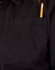 Field Coat in Basic Black front pocket close up. Pencil is in the pen pocket slot.