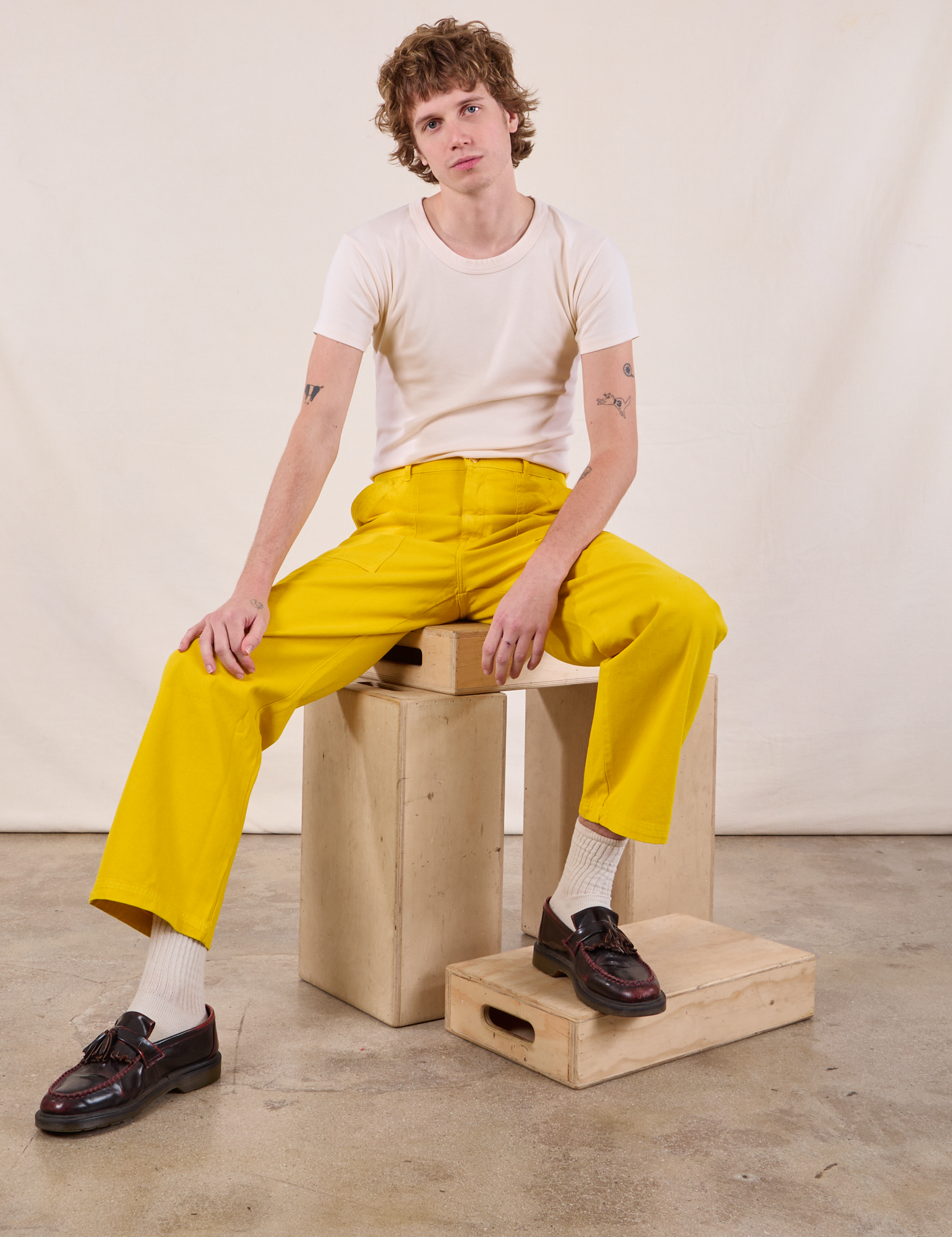 Quinn is wearing Work Pants in Golden Yellow and Burly Tee in Vintage Tee Off-White