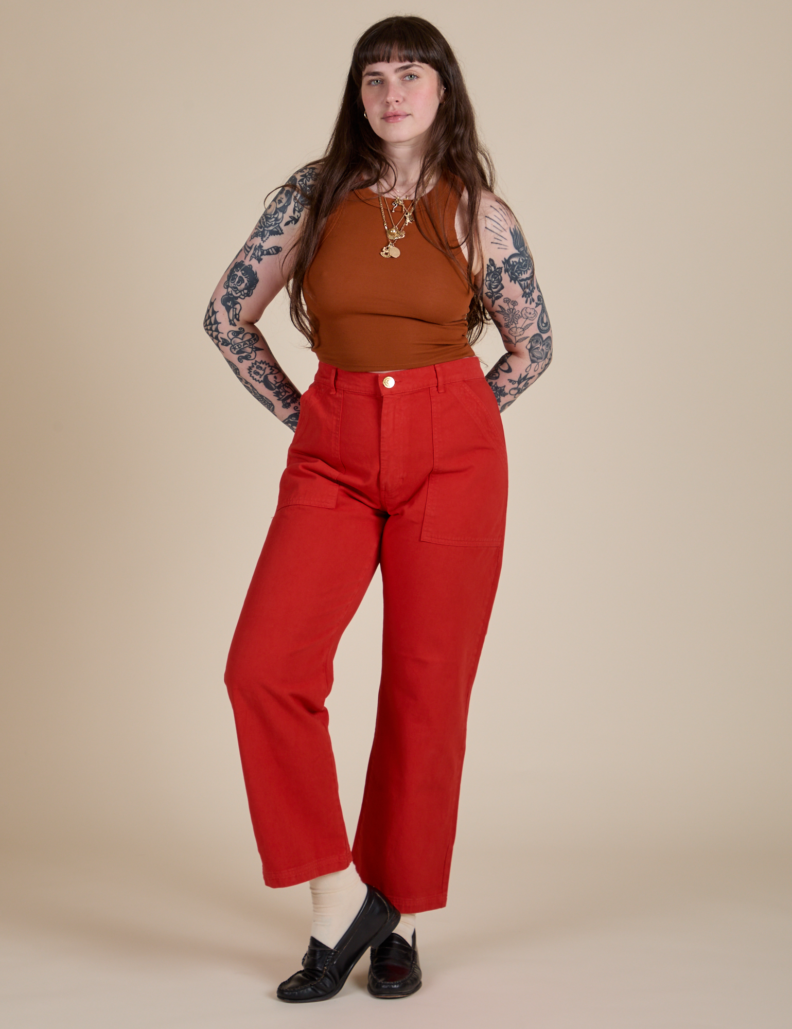 Sydney is wearing Racerback Tank in Burnt Terracotta and mustang red Work Pants