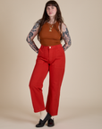 Sydney is wearing Racerback Tank in Burnt Terracotta and mustang red Work Pants