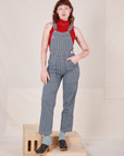 Alex is 5'8" and wearing P Railroad Stripe Denim Original Overalls paired with paprika Sleeveless Turtleneck