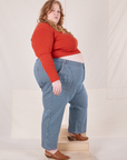 Side view of Railroad Stripe Denim Work Pants and paprika Long Sleeve V-Neck tee worn by Catie
