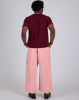 Back view of Drop Pocket Cargo Pants in Baby Pink and red wine Organic Vintage Tee on Isaac