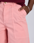 Close up of Isaac's hand in the front pocket of Longline Work Shorts in Baby Pink