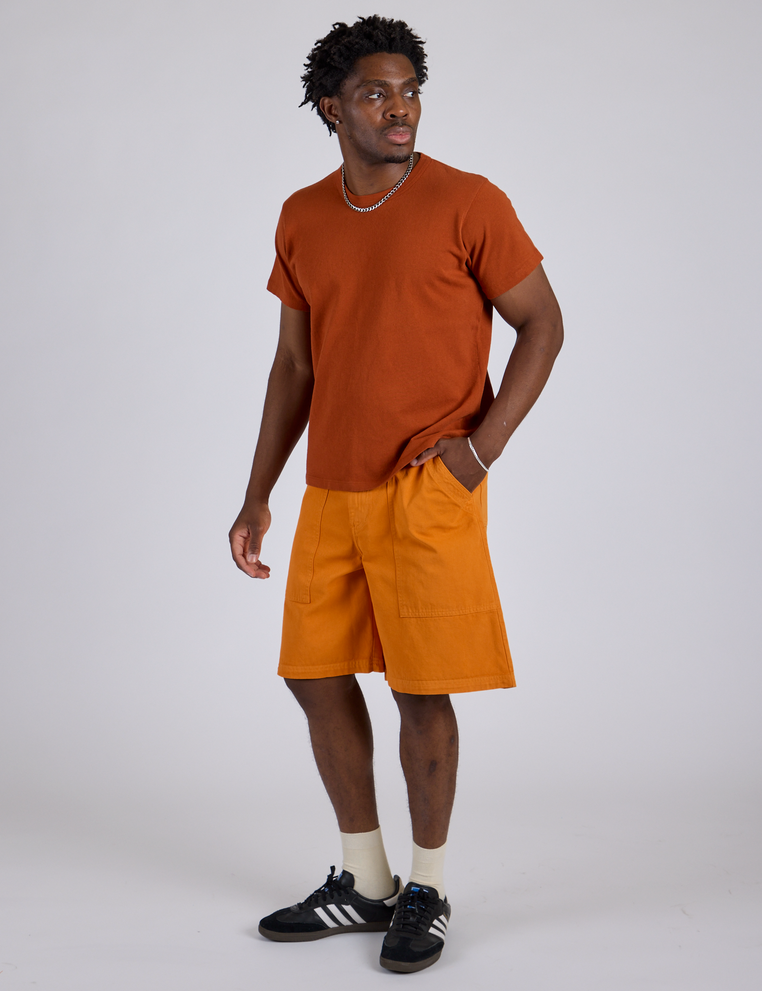 Angled front view of Longline Work Shorts in Creamsicle Orange and burnt terracotta Organic Vintage Tee