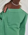 Close up of Isaac's hand in the back pocket of Longline Work Shorts in Seafoam Green