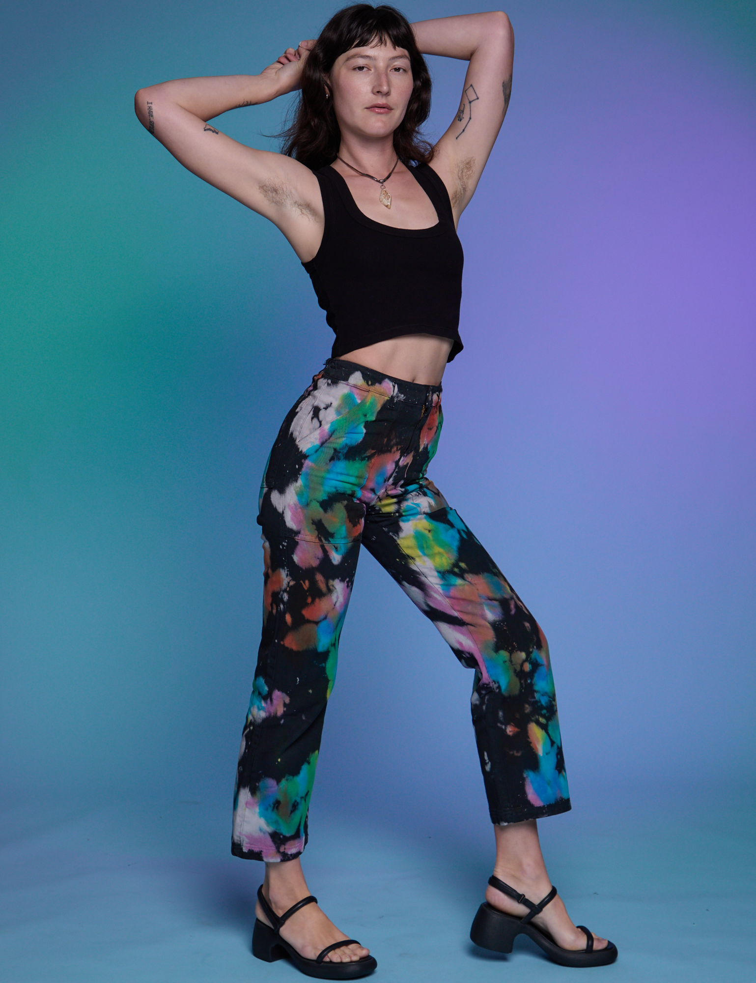 Side view of Work Pants in Rainbow Magic Waters and black Cropped Tank on Alex