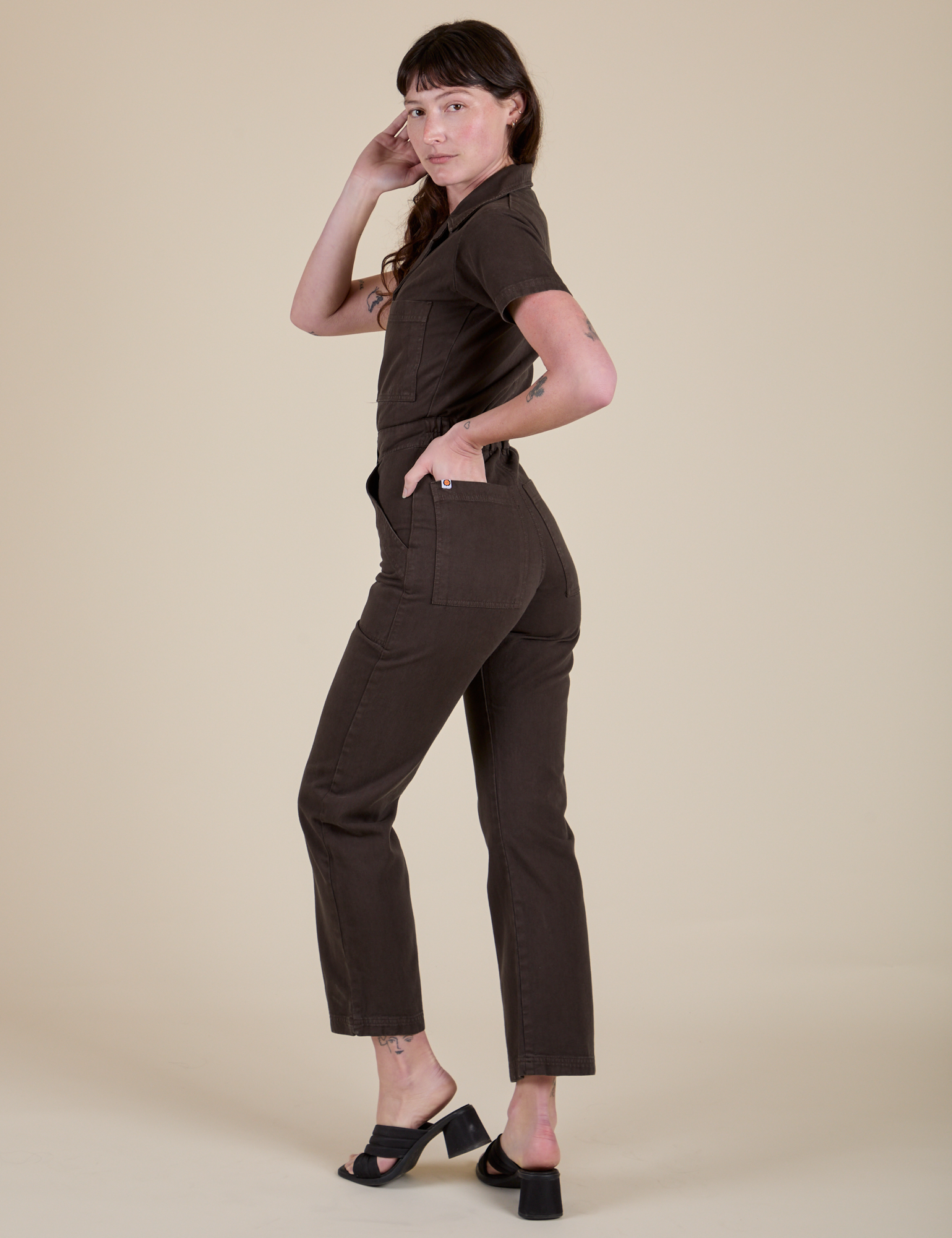 Angled back view of Short Sleeve Jumpsuit in Espresso Brown on Alex