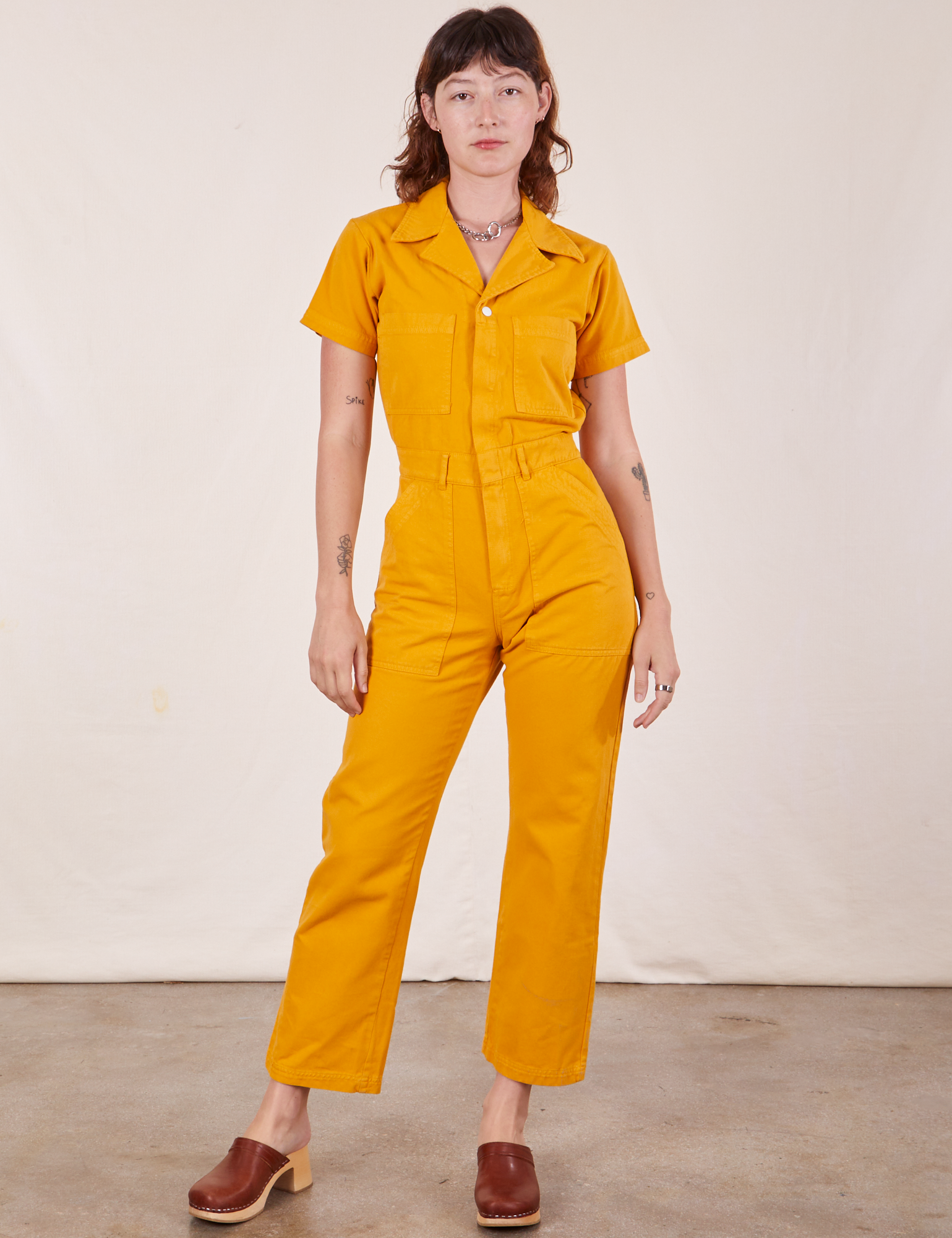 Alex is 5&#39;8&quot; and wearing XS Short Sleeve Jumpsuit in Mustard Yellow