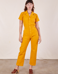 Alex is 5'8" and wearing XS Short Sleeve Jumpsuit in Mustard Yellow