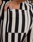 Close up of Tiara's hand in the back pocket of Black Stripe Work Pants in White
