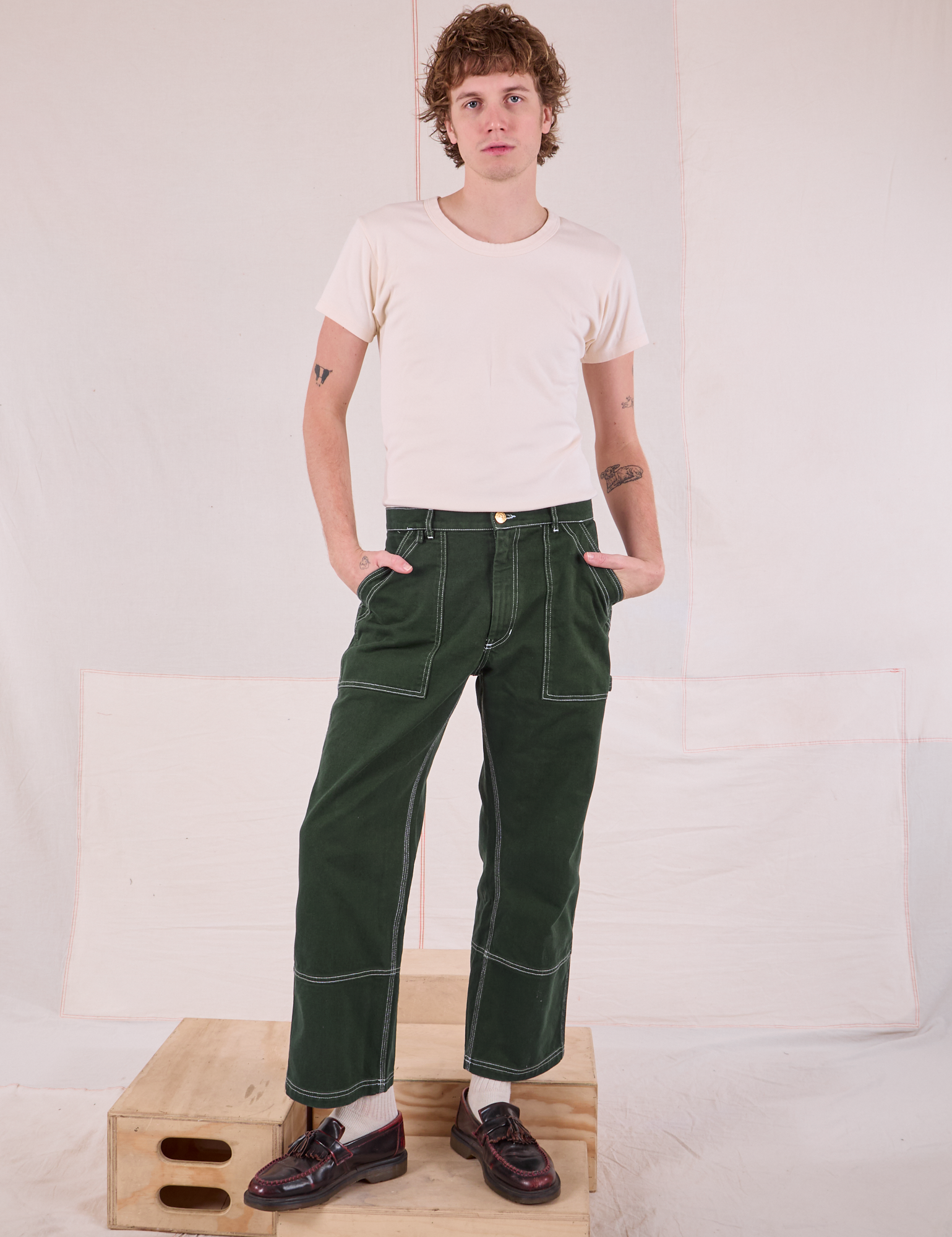 Quinn is 6&#39;4&quot; and wearing M Carpenter Jeans in Swamp Green paired with a Organic Vintage Tee in Vintage Tee Off-White