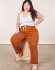 Ashley is wearing Cropped Rolled Cuff Sweatpants in Burnt Terracotta and vintage off-white Cropped Tank Top