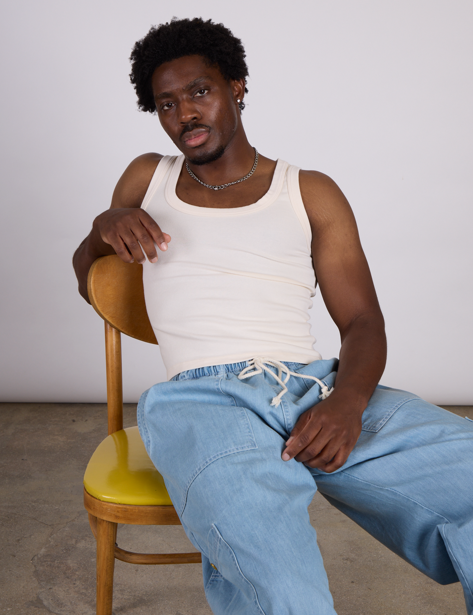 The Tank Top in Vintage Tee Off-White and light wash denim drop pocket pants. on Isaac