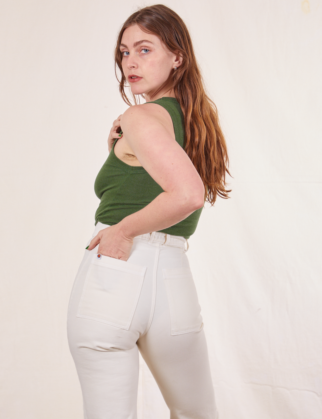 Tank Top in Dark Emerald Green back view on Allison wearing vintage off-white Western Pants. Allison has one hand in the back pocket of the pants.