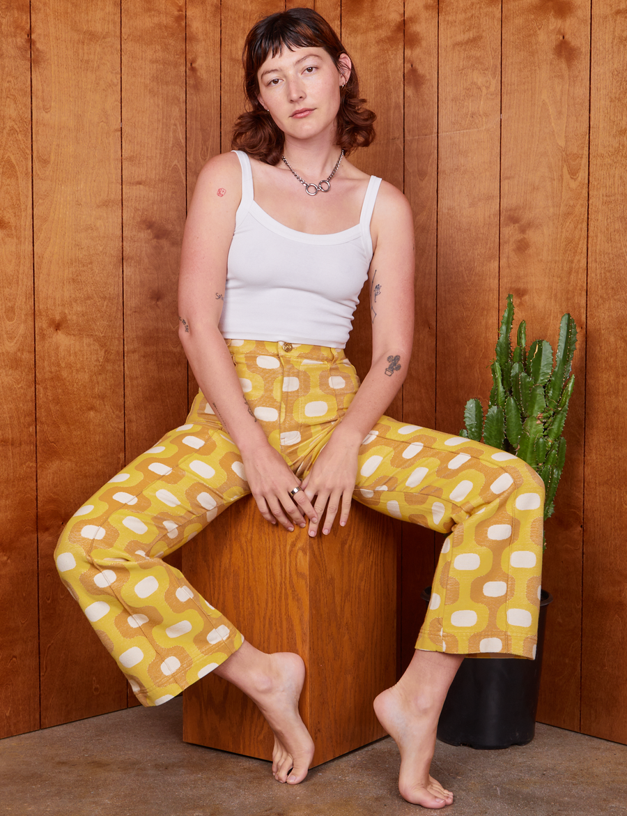 Alex is sitting on wooden box wearing Western Pants in Yellow Jacquard